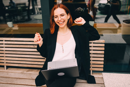 Beautiful woman working on laptop at outdoors cafeの写真素材
