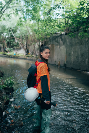 Young beautiful woman digger walks along the rain collector