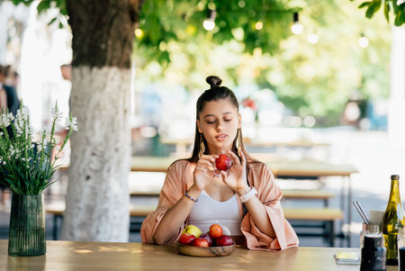 Young beautiful hipster woman sitting in veranda cafe in street.