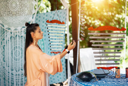 A young beautiful woman plays a musical instrument in the garden