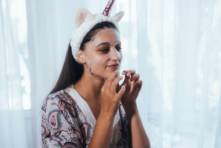 Beautiful model applying cosmetic cream treatment on her face
