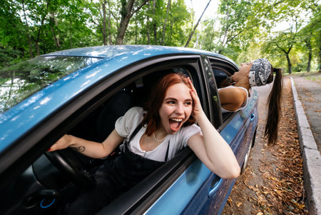 Two girlfriends fool around and laughing together in a car