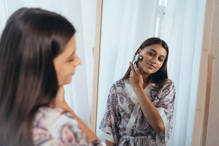 Woman massaging her cheek with massage Y-shaped ball roller.の写真素材