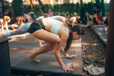 A woman does yoga together with her group in the open airの写真素材