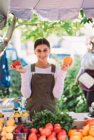 Young saleswoman holding home-grown tomatos in handsの写真素材