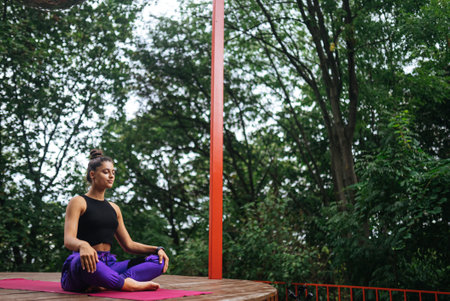 Young woman is practising yoga sitting in the lotus position