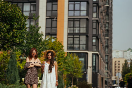 Two happy tourists with a phone on a city streetの写真素材