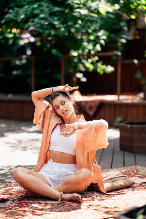 Young woman is practising yoga sitting on a wooden podiumの写真素材