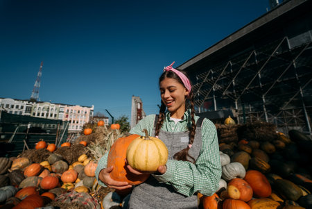 A young female seller is showing the autumn harvestの写真素材