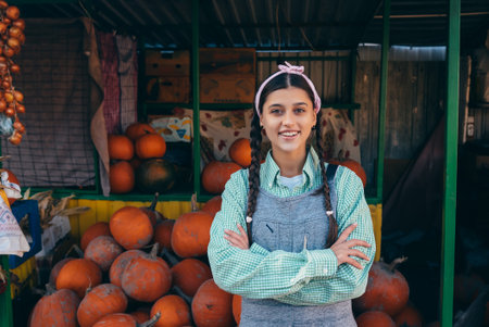 Farmer woman sells autumn pumpkin harvest at the marketの写真素材