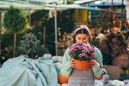 Woman holding decorative flower in flower pot on the market.の写真素材