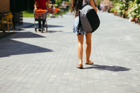 Young woman with backpack walks around the city.の写真素材