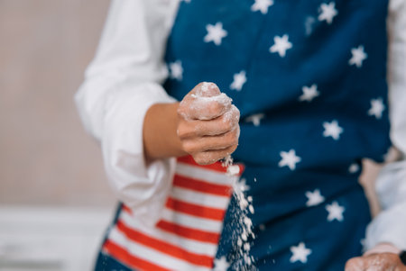 Young housewife in an apron kneads dough with her hands.の写真素材