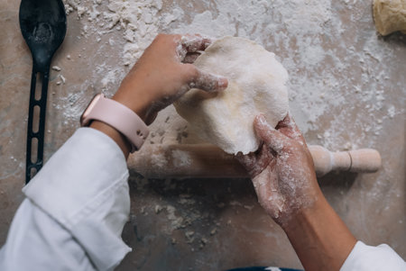 Smiling woman in kitchen holding cute white Maltese dogの写真素材