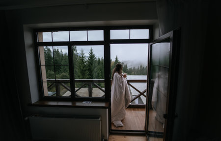 Woman drinking tea on cozy balcony of a country house.の写真素材