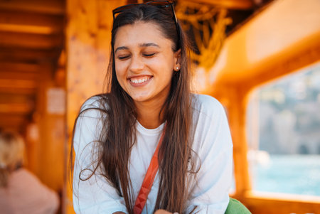 A Joyful Young Woman is Enjoying a Scenic and Relaxing Boat Ride on Beautiful Waterの写真素材
