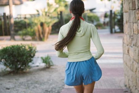 A Young Woman Enjoying a Leisurely Walk in a Casual Outfit While Outdoors in Natureの写真素材