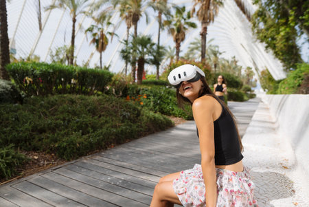 A young woman enjoying an outdoor adventure with a VR headset to explore new worldsの写真素材