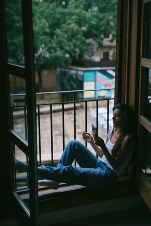 A person enjoys peaceful reading moments by the window, fostering mindfulness and tranquilityの写真素材