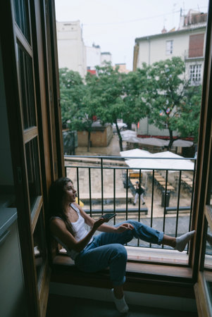 Relaxing peacefully in a cozy indoor space while enjoying a beautiful view outside the windowの写真素材