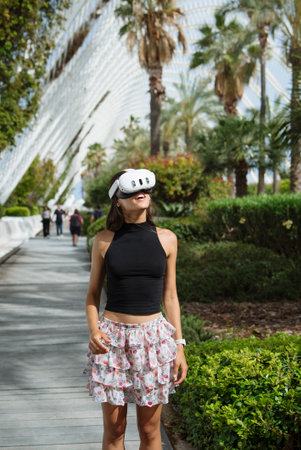 A young woman is immersed in a captivating virtual reality experience in a tropical paradiseの写真素材