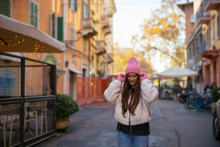 A Young Woman Wearing a Pink Beanie on a Beautiful and Charming Street During the Day