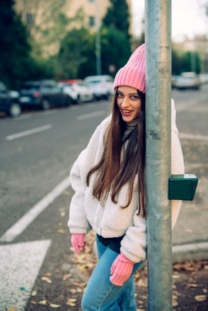 A Trendy Young Woman Joyfully Posing in an Urban Street While Embracing Winter Fashionの写真素材