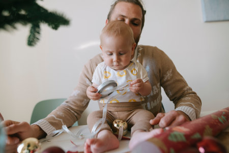 A Child Joyfully Playing with Colorful Christmas Decorations in Their Cozy Home Environmentの写真素材