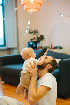A Joyful and Loving Father Enjoys Playtime with His Baby at Their Cozy Home Together