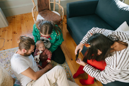 A Family Gathering Featuring a Baby Happily Bonding Together in a Cozy Living Room Settingの写真素材