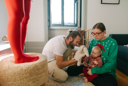 A Family Joyfully Celebrating the Holidays Together with Their Baby and Fun Colorful Propsの写真素材