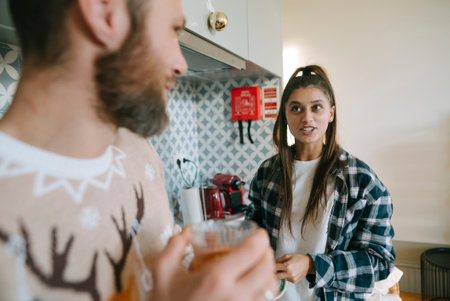 A couple is enjoying refreshing drinks in a cozy kitchen setting that feels warm and invitingの写真素材