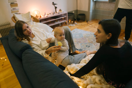 A Cozy Family Gathering with a Baby in a Warm, Inviting Living Room Full of Joyの写真素材