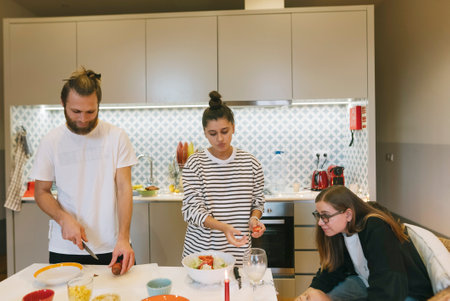 Enjoying the experience of Cooking Together in a Beautifully Designed Modern Kitchen Settingの写真素材