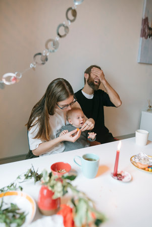 A Joyful Family Moment Feeding the Baby with Lots of Love, Happiness, and Laughterの写真素材