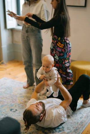 Playful family interaction with a baby in a cozy, joyful living room filled with warmth