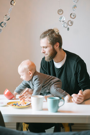 A father and his baby are bonding over a cozy breakfast filled with laughter and love