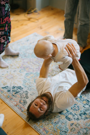A Playful Interaction Between a Loving Father and His Baby in a Cozy, Comfortable Roomの写真素材