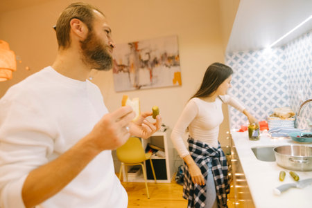 Enjoying the joy of casual cooking together in a warm and cozy kitchen environmentの写真素材