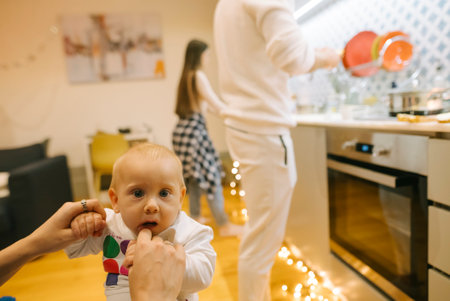Family Moments A Baby and Their Loving Parents Enjoying Time in a Cozy Kitchen Togetherの写真素材