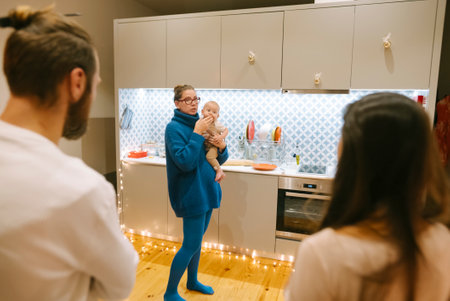 A cozy family gathering featuring a baby is taking place in a modern kitchen settingの写真素材