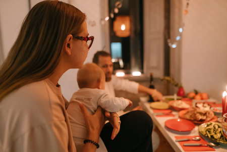 A Heartwarming Family Dinner Gathering Featuring a Baby in a Cozy Atmosphere Full of Joyの写真素材