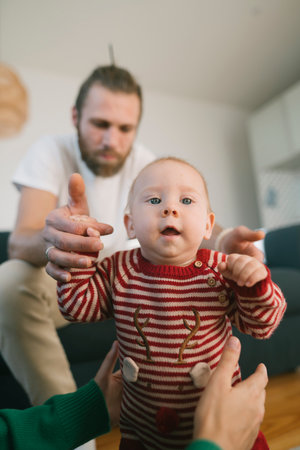 Family Moments A Baby Delightfully Learning to Walk with the Loving Support of Dad