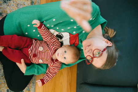 Enjoying Cozy Family Moments with Baby and Loving Mother While Wearing Holiday Sweaters