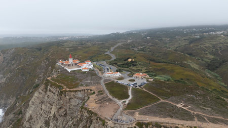 A breathtaking aerial view showcasing a coastal lighthouse and the captivating surrounding landscapeの写真素材