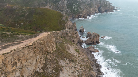 The breathtaking stunning coastal cliffs gracefully overlook the shimmering turquoise watersの写真素材