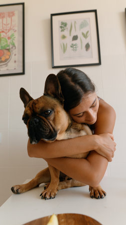 A heartwarming scene of a dog and owner joyfully embracing in a cozy, decorated homeの写真素材
