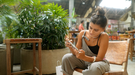 Young Woman Engaged with Phone in Cozy Caf Setting