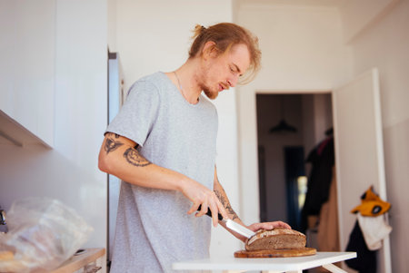 Individual slicing bread on countertop with peaceful planning attitude