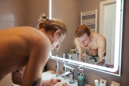 Person calmly examines how they present themselves visuallyの写真素材